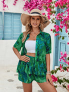 Woman smiling in a green matching shorts and top set with a tropical pattern