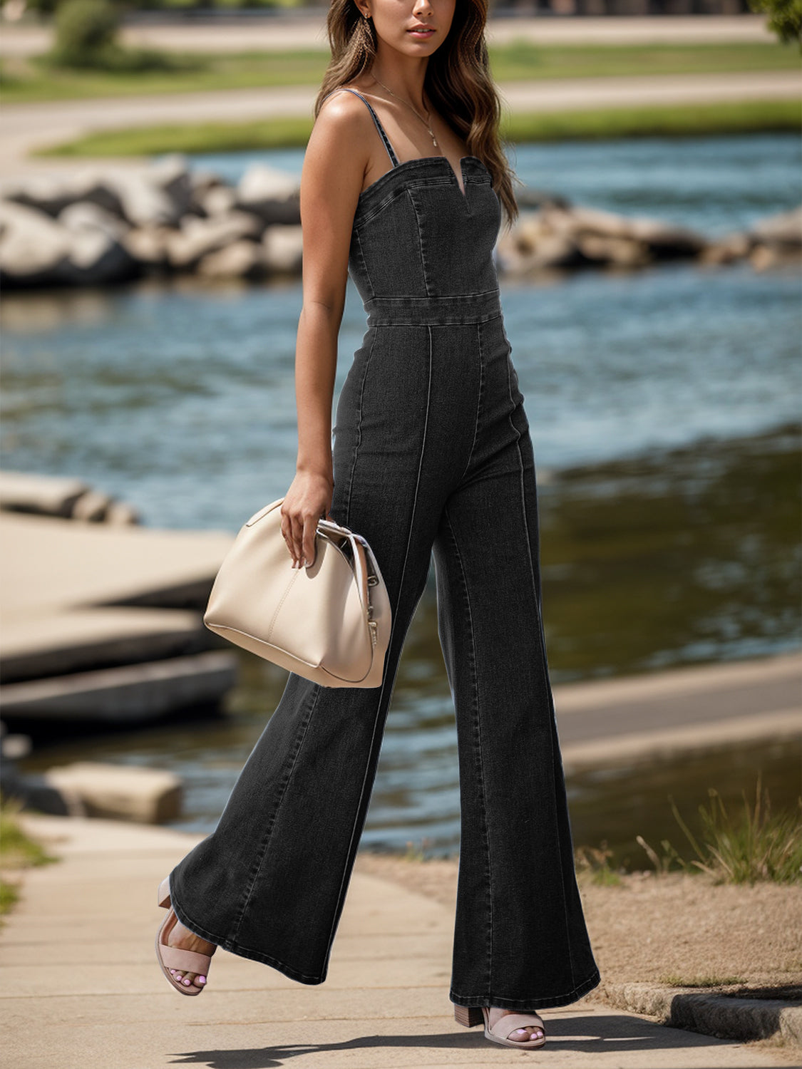 Two images of a woman wearing chic flared denim overalls: one in black and one in blue. Each paired with a white top, she is walking along a tree-lined path, accessorized with a necklace and carrying a cream handbag.