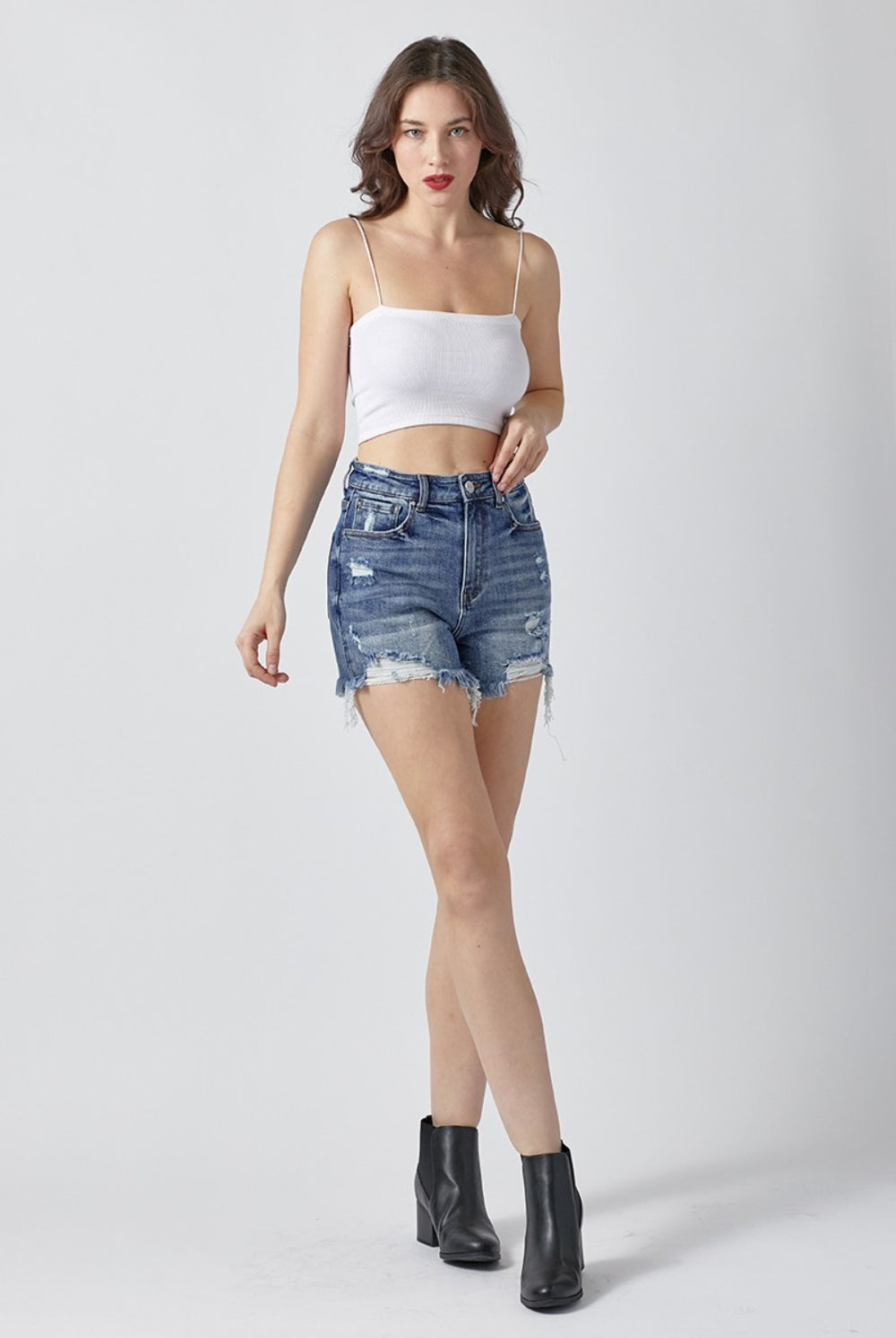 Close-up of Chic Distressed Denim Shorts, with attention to the frayed hem and detailed distressing, embodying a trendy and casual summer vibe.