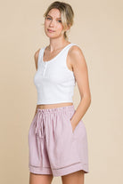 Woman wearing mauve high waist drawstring cotton shorts, perfect for casual or active wear.