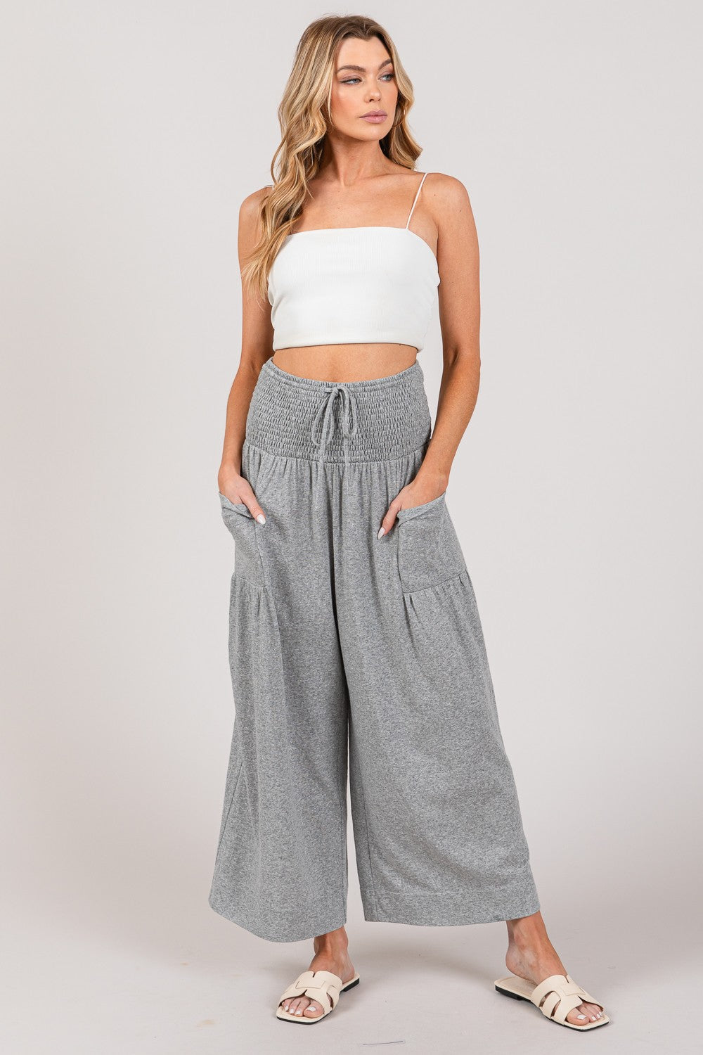 Woman wearing stylish gray high waist smocked drawstring pants, perfect for chic outfits.