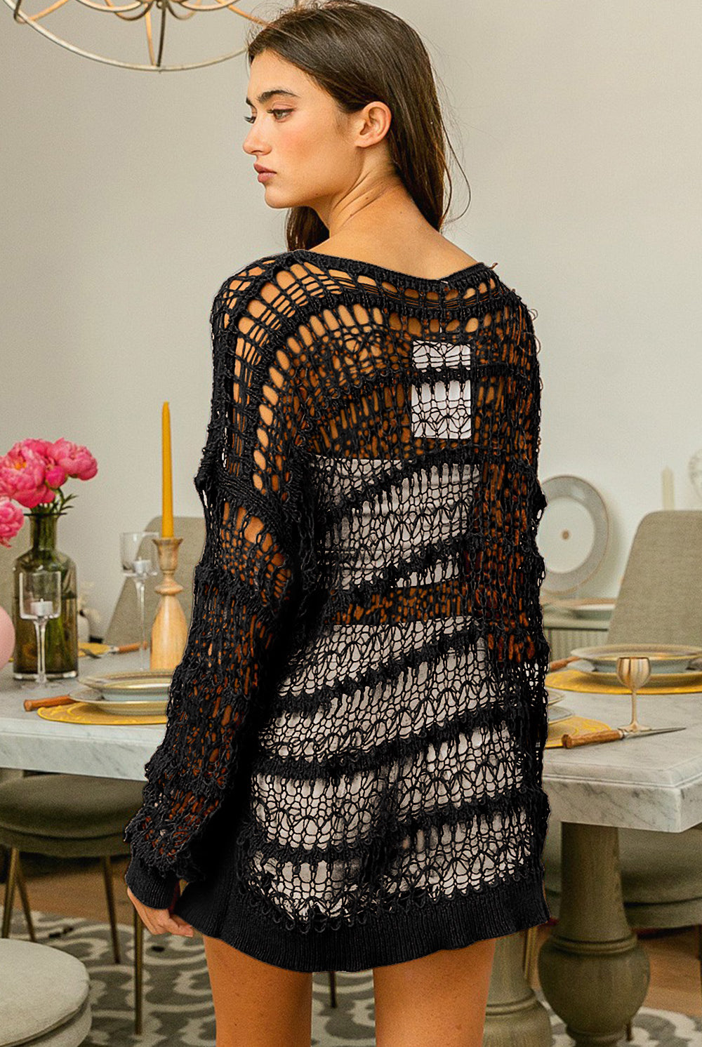 Stylish woman posing in a black long sleeve crochet knit cover-up, perfect for versatile layering.