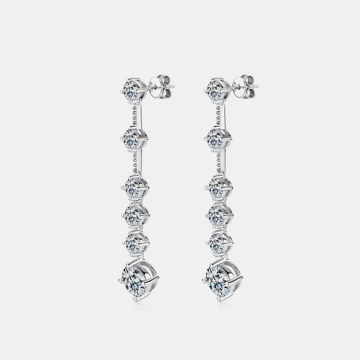 Person wearing sterling silver linear drop earrings, adding a touch of understated elegance.