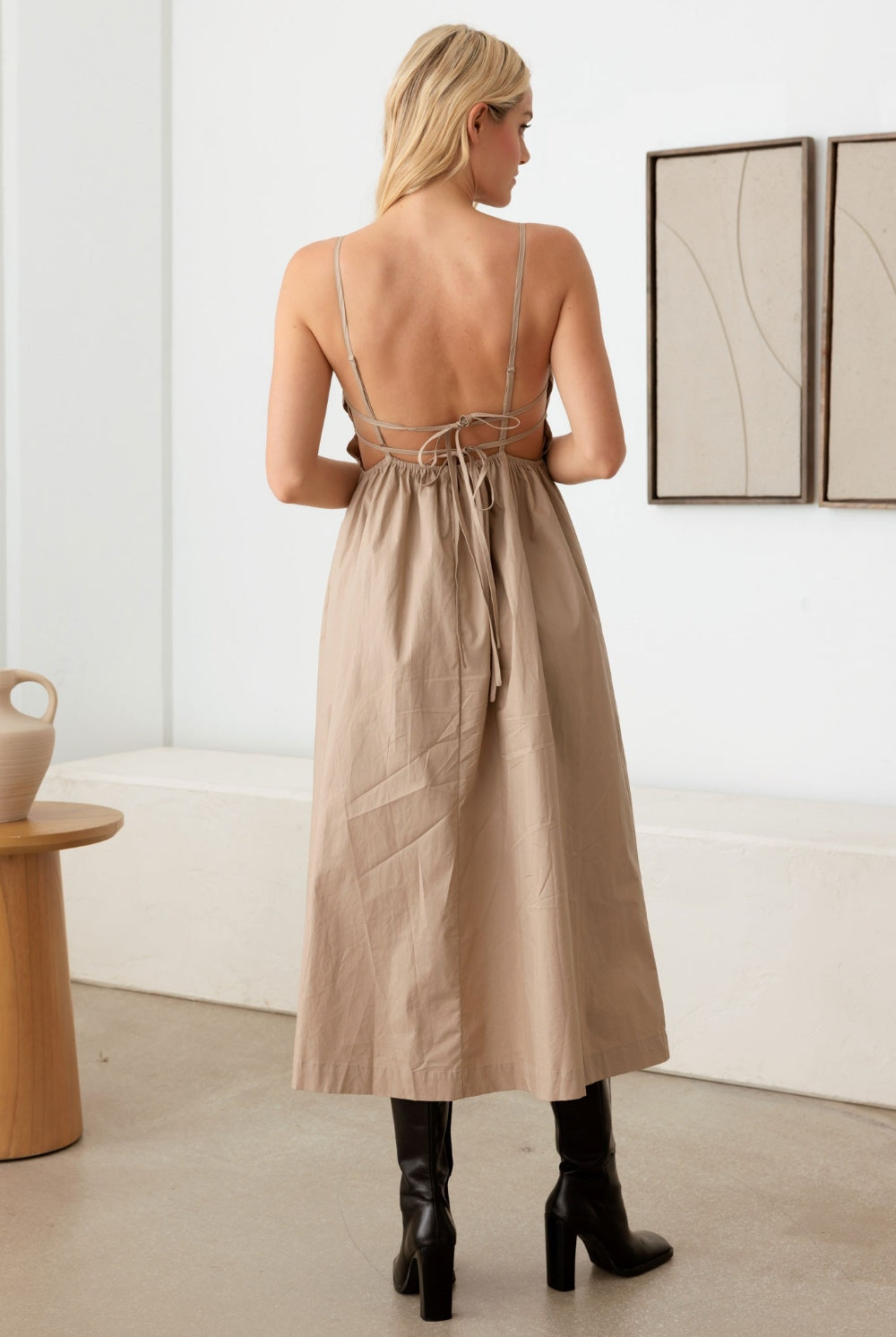 Stylish woman wearing a taupe cami dress with a tie back and open back, perfect for elegant outings.