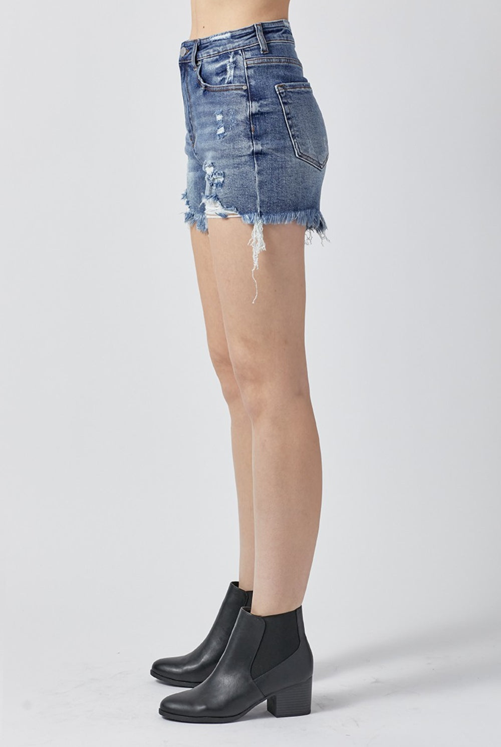 Close-up of Chic Distressed Denim Shorts, with attention to the frayed hem and detailed distressing, embodying a trendy and casual summer vibe.