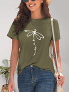 Fashionable woman wearing a black short sleeve tee featuring a bold dragonfly graphic, pairing it with casual denim for a day out.