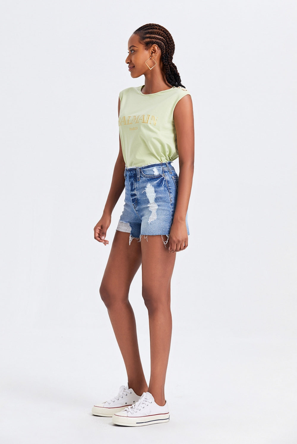 Model showcasing high waist denim shorts with fringed hem