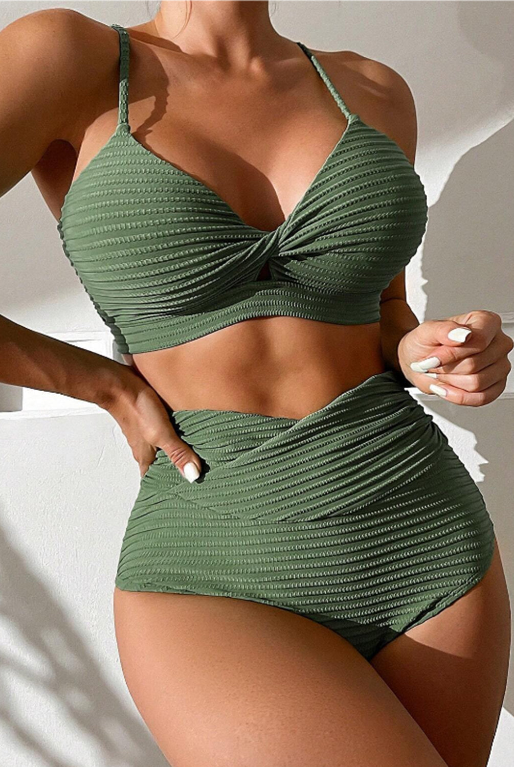 Model presenting a stylish high-waisted bikini set in vibrant green and blue