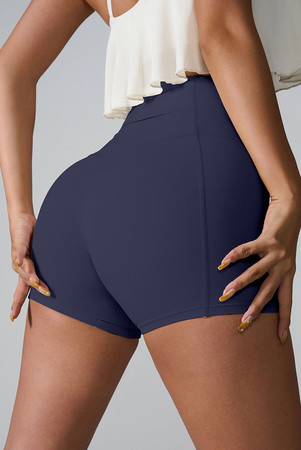 Active woman in GemThreads Boutique's high-waisted active shorts, with phone tucked in back pocket.
