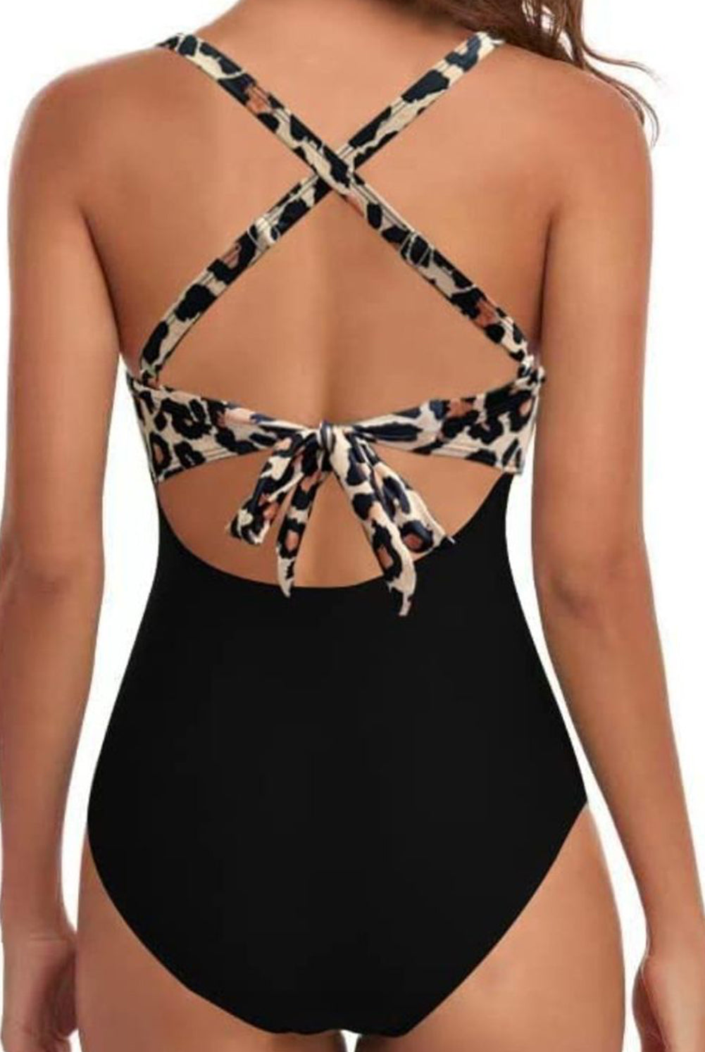 Woman in pink one-piece swimsuit with crisscross design and cutout, a stylish swimwear choice.