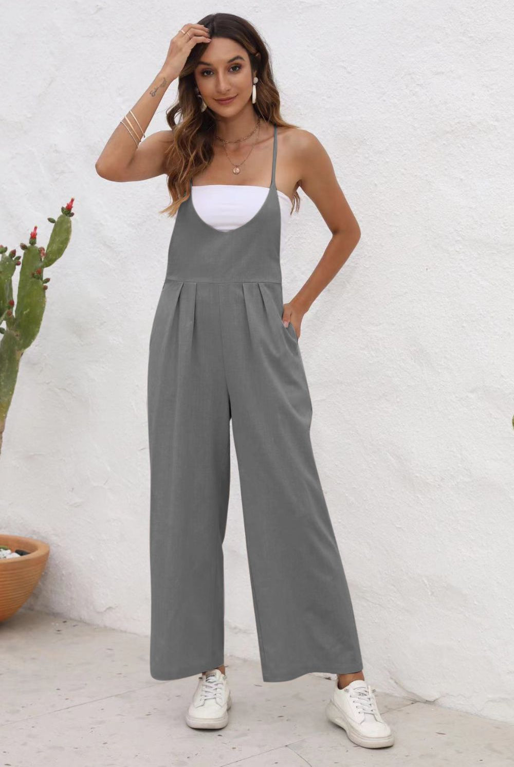 Stylish person posing in a sleeveless wide-leg jumpsuit, perfect for versatile looks.