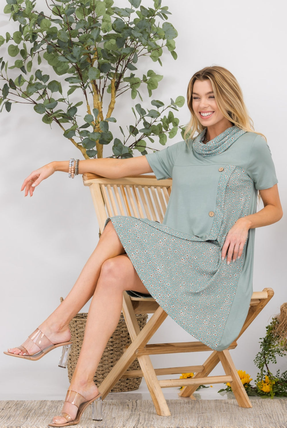 A woman beams in her Chic Asymmetrical Short Sleeve Dress, boasting an innovative hemline and detailed buttons, perfect for a fresh and fashionable look.