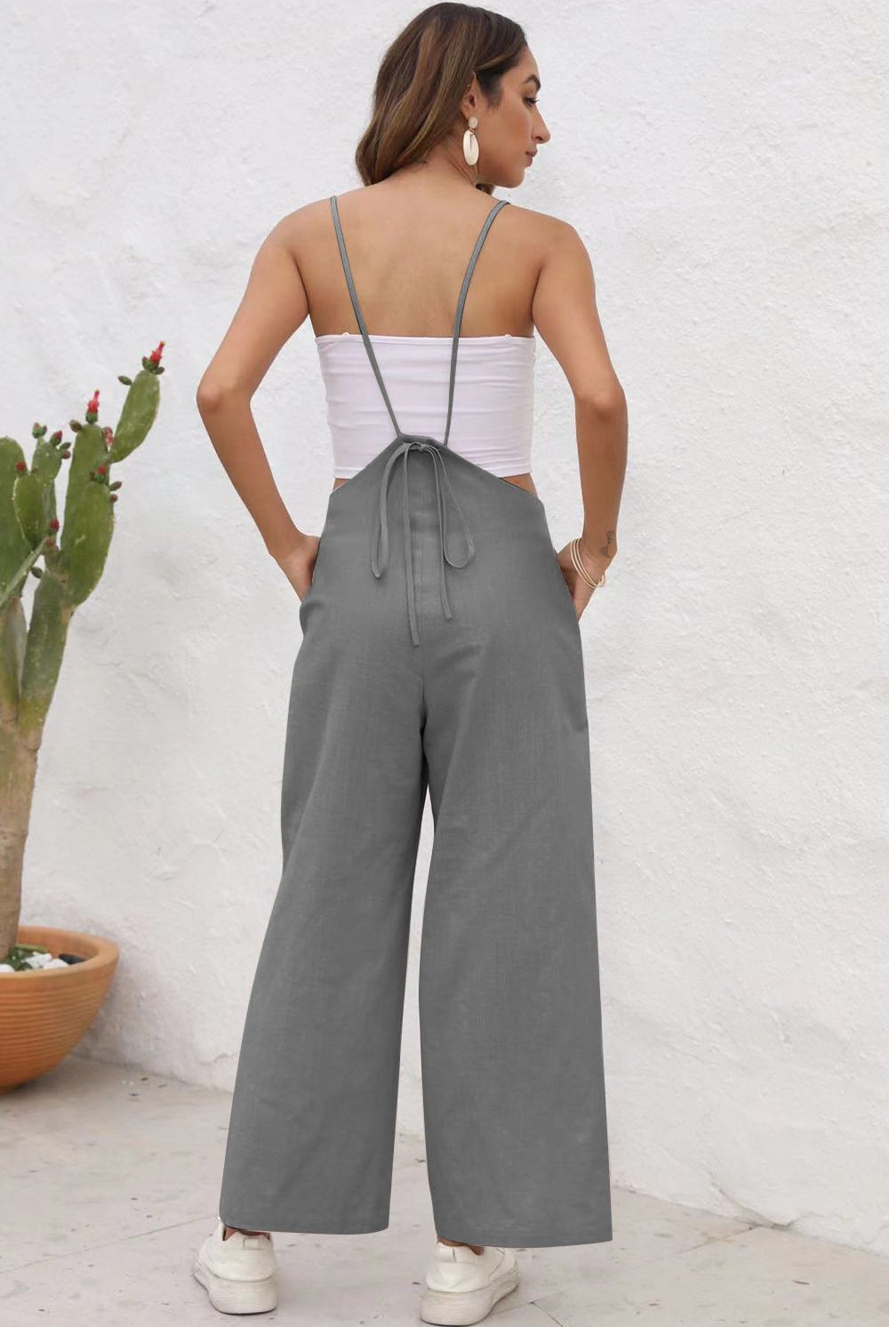 Stylish person posing in a sleeveless wide-leg jumpsuit, perfect for versatile looks.
