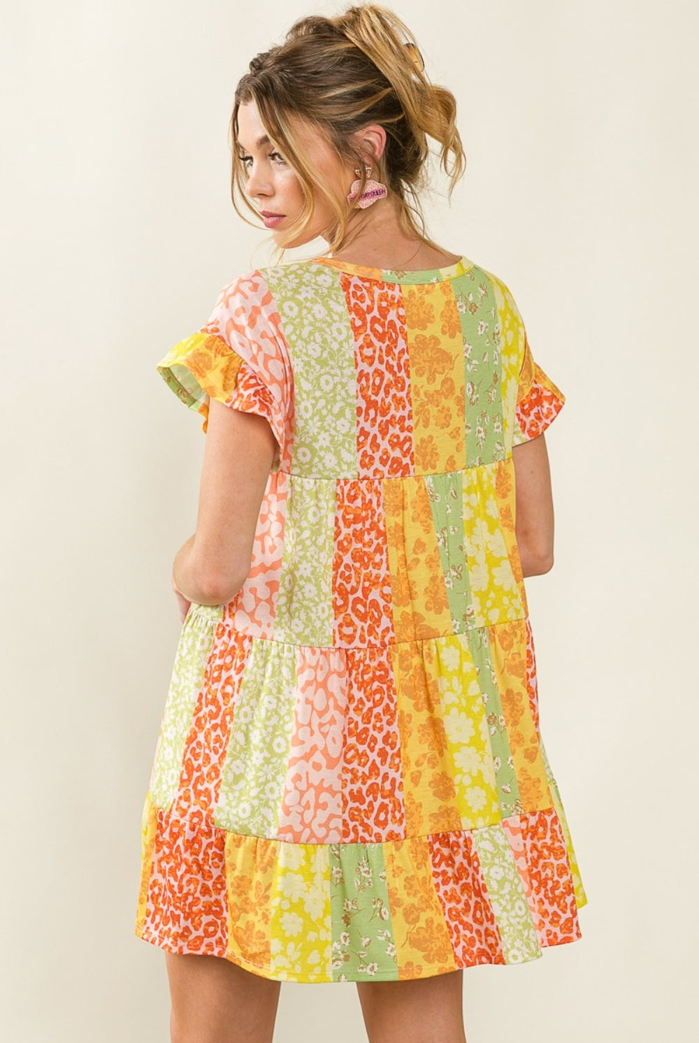 Chic individual in a vibrant patchwork swing dress with summer-inspired color palette and patterns.