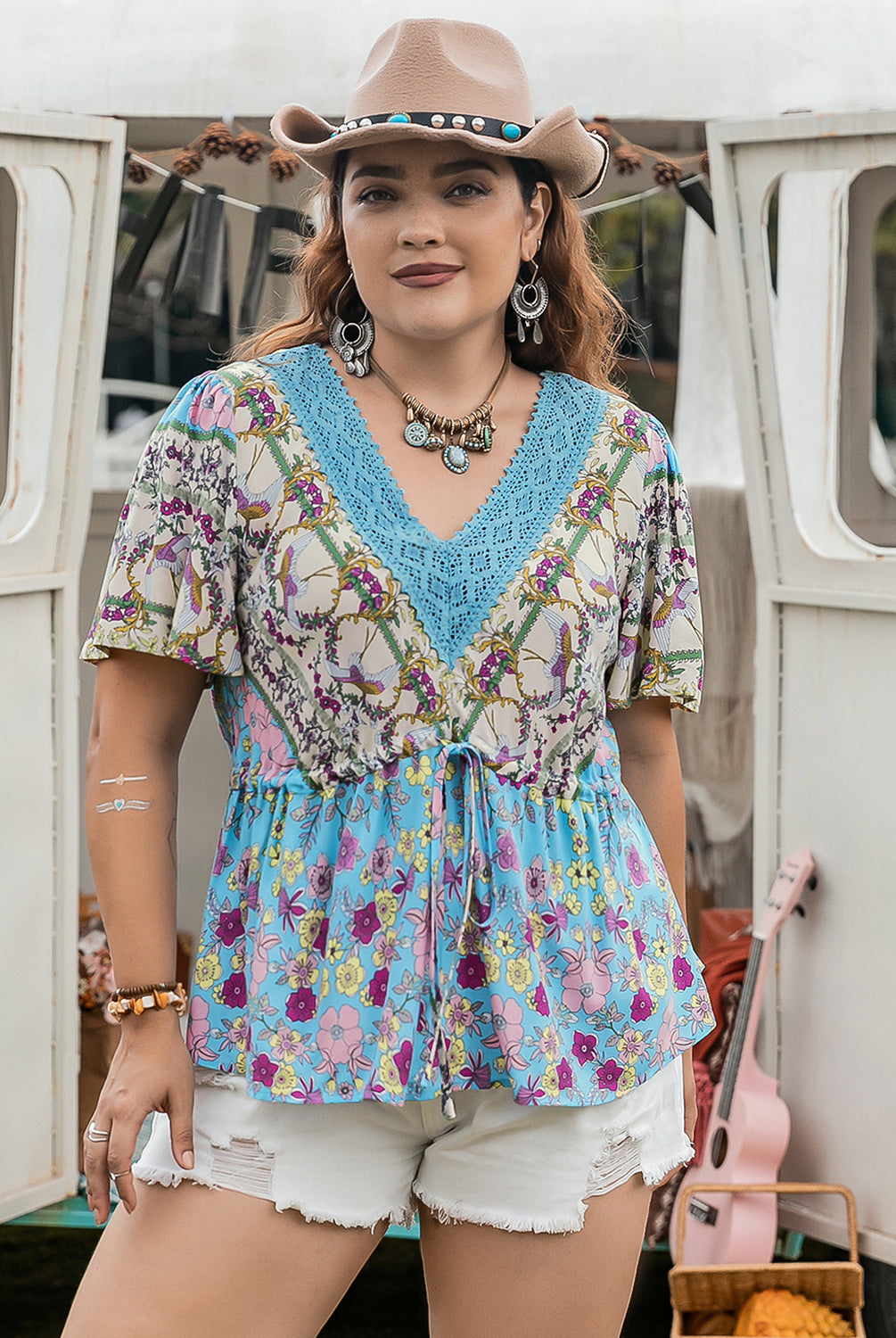 Confident woman sporting a colorful plus size blouse with floral and lace detail