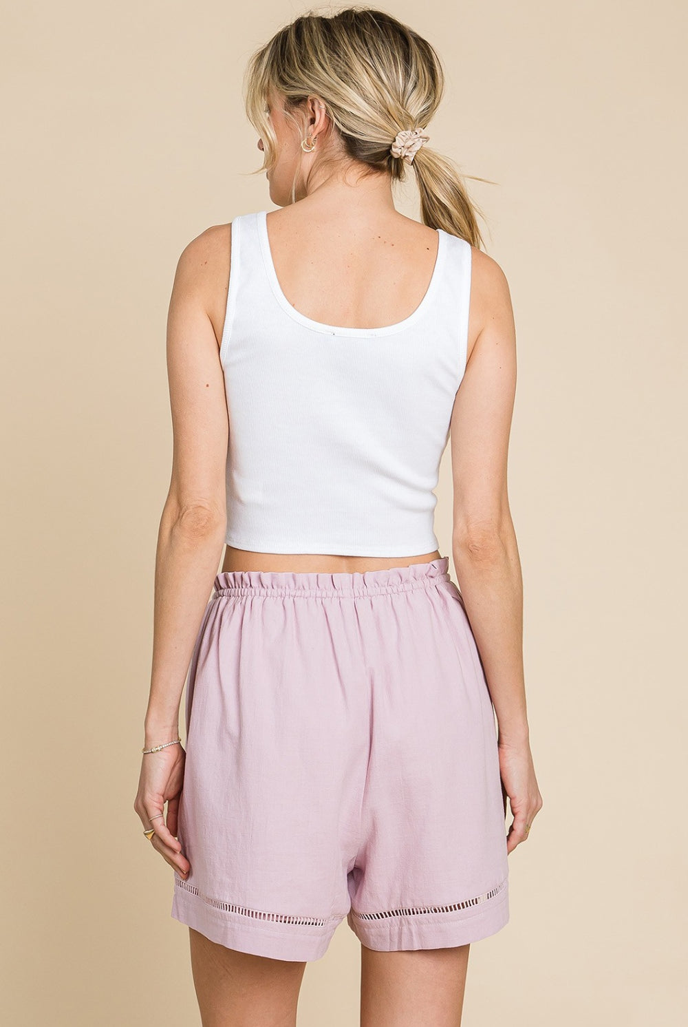 Woman wearing mauve high waist drawstring cotton shorts, perfect for casual or active wear.