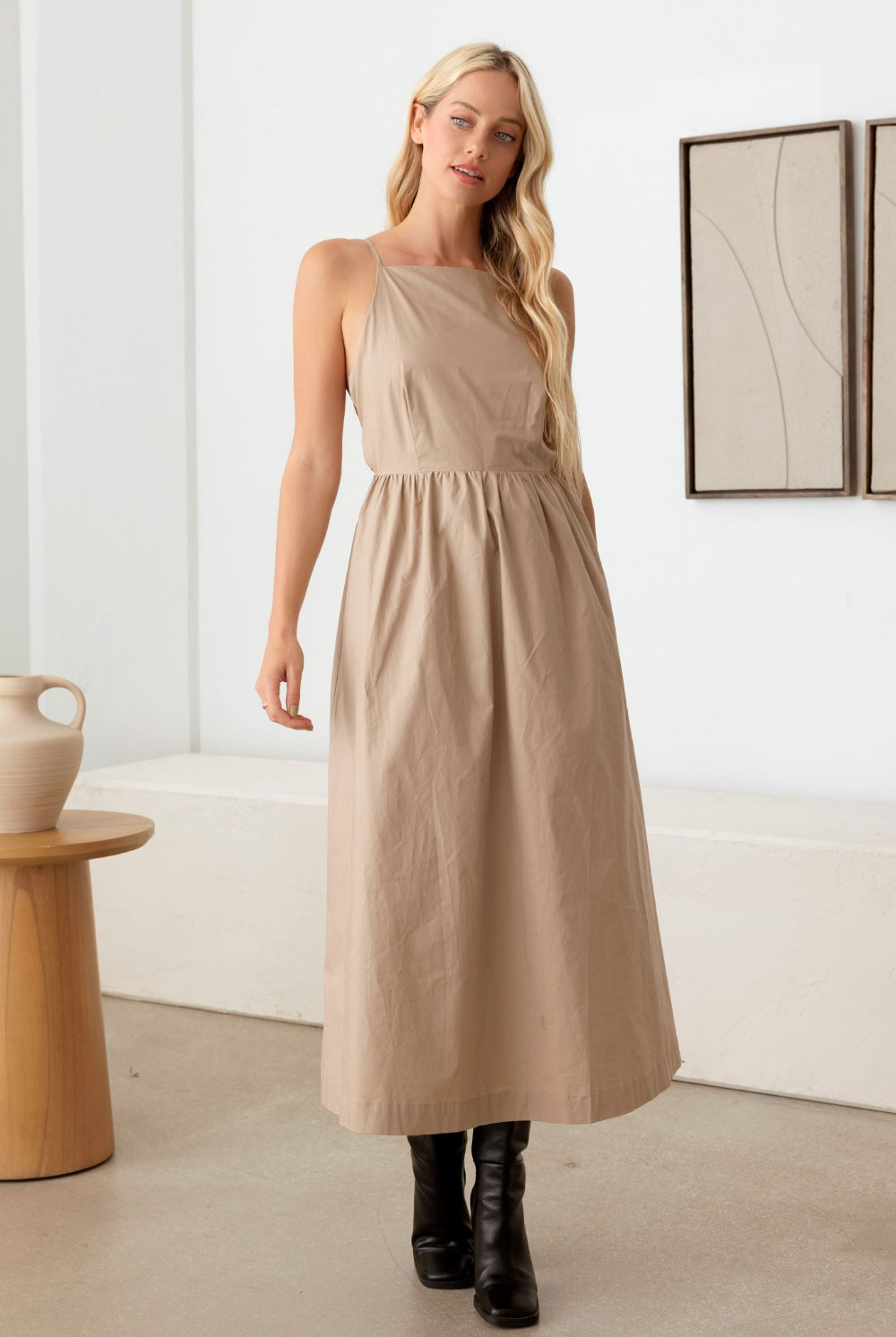 Stylish woman wearing a taupe cami dress with a tie back and open back, perfect for elegant outings.
