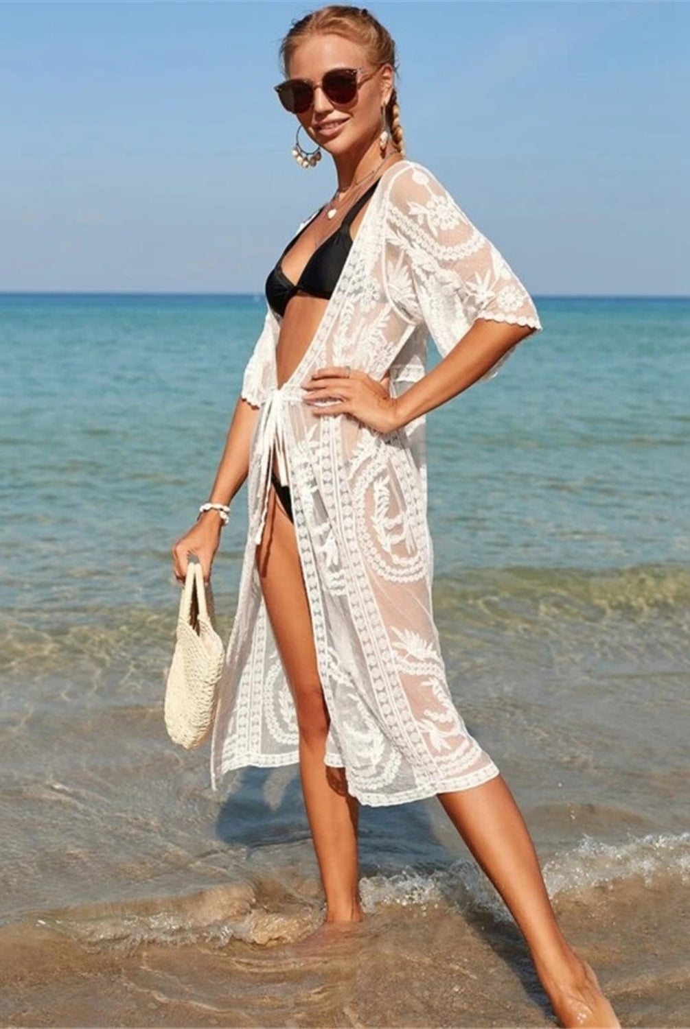  Fashionable woman wearing a white cover up with half sleeves on the beach.