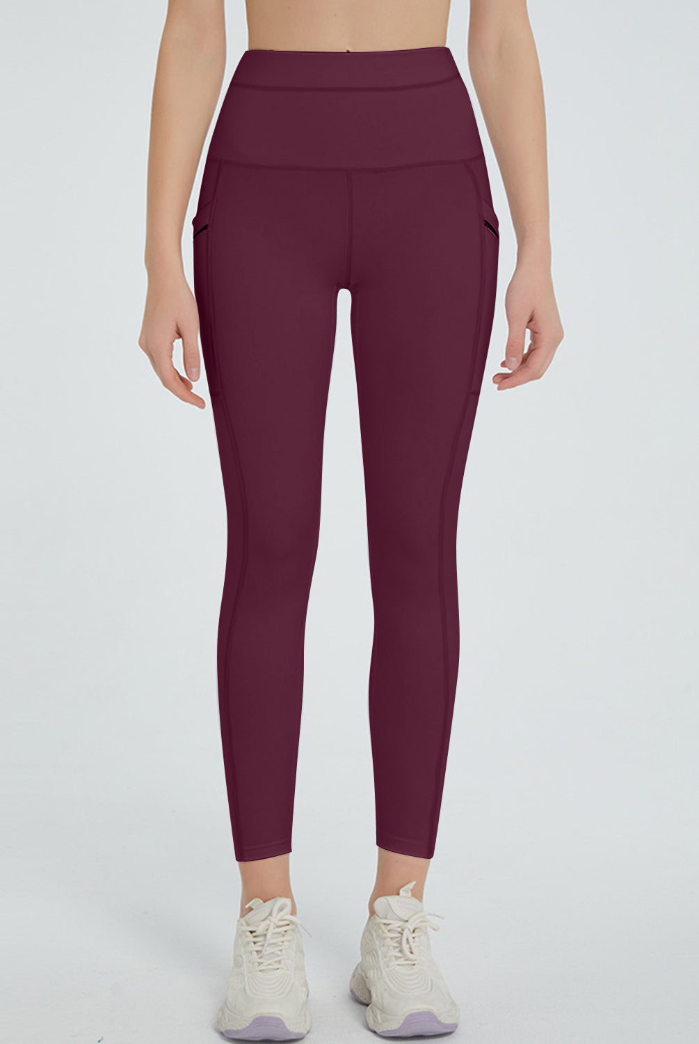 Active woman posing in versatile high-waisted leggings with a handy pocket, paired with athletic sneakers.