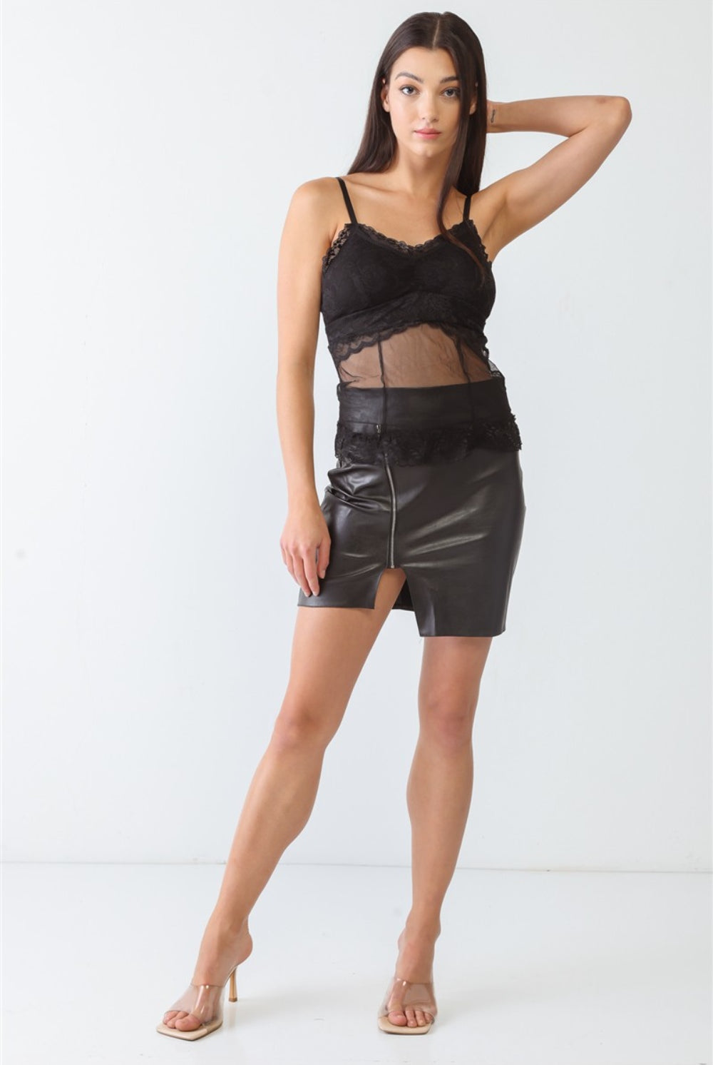 A woman models a sophisticated black lace bustier top with sheer panel detailing, epitomizing modern elegance.