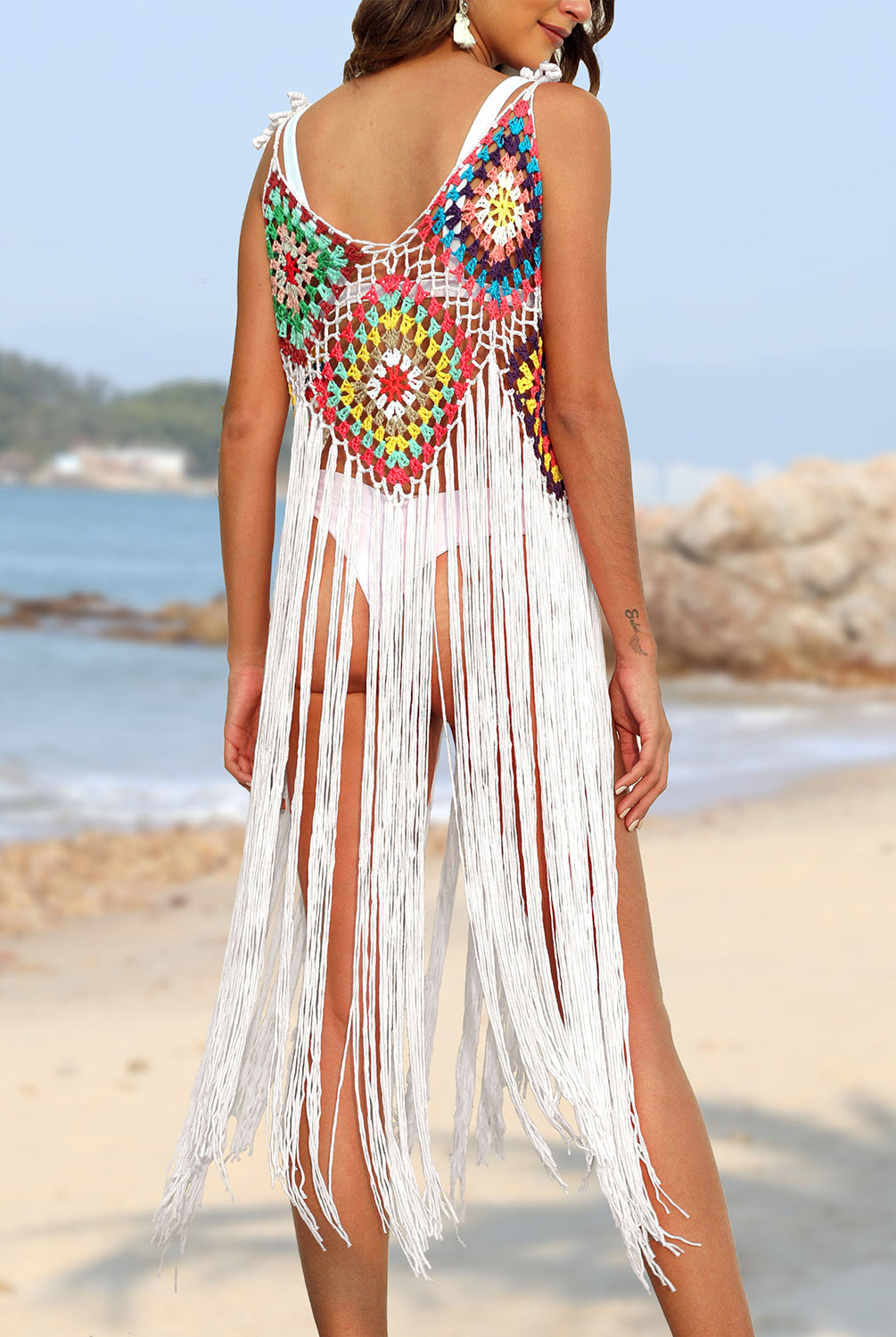 Model stylishly donning a colorful fringe cover up swimsuit on the beach