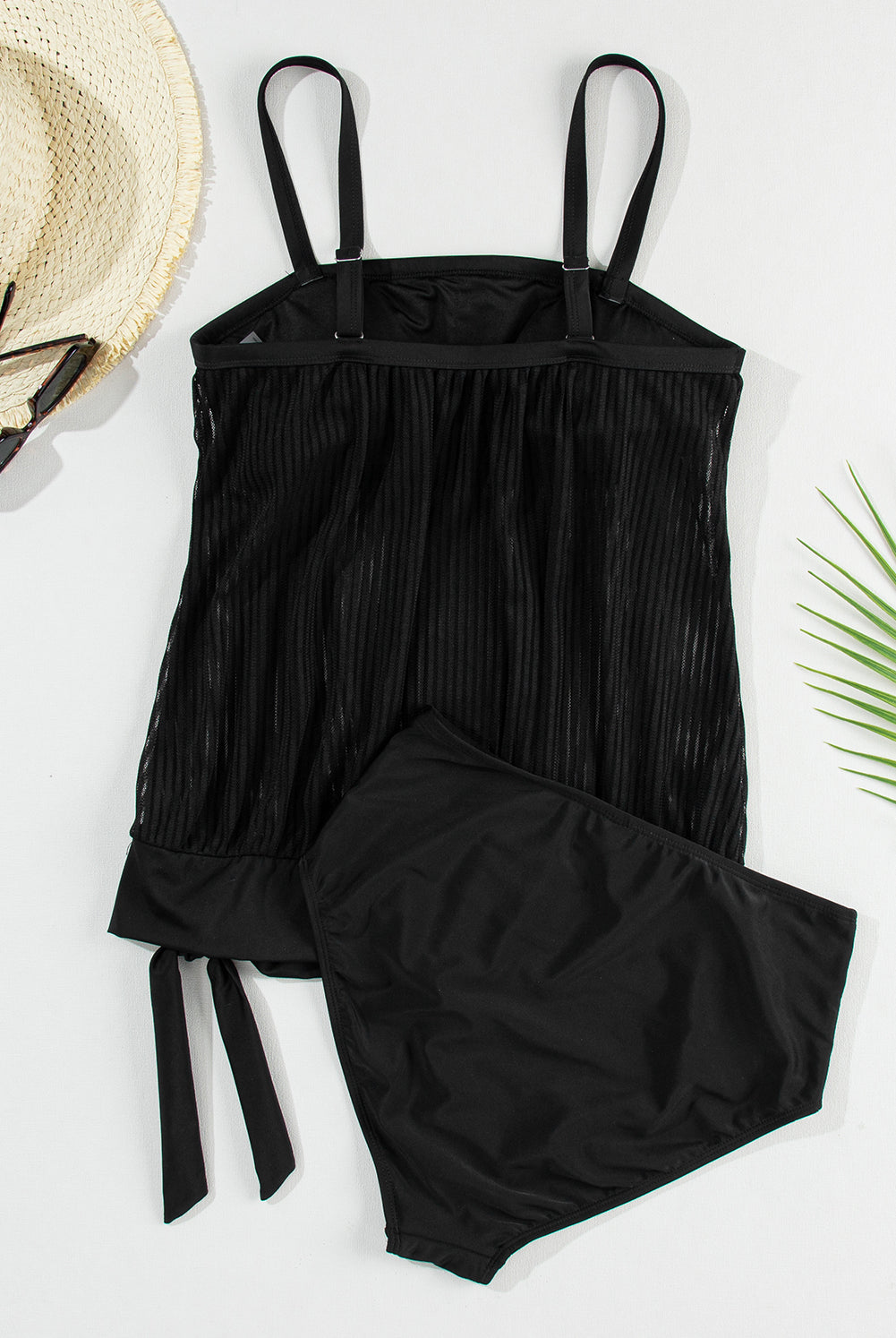 Woman on the beach wearing a square neck spaghetti strap tankini set in black, perfect for summer.
