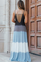 Stylish woman wearing a color block scoop neck maxi dress with a side slit, featuring blue and black tones.