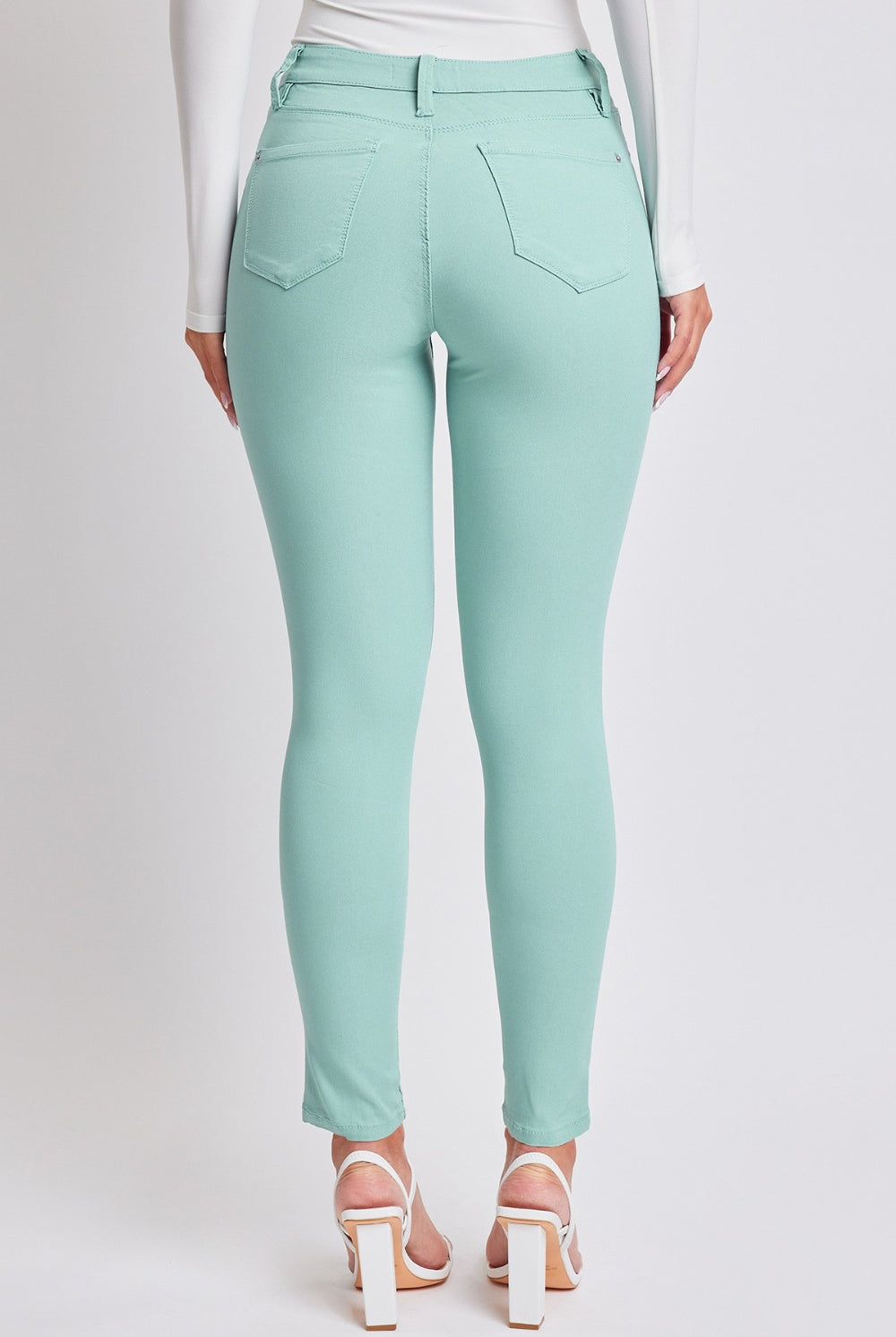 Elegant model wearing chic seafoam mid-rise skinny jeans, epitomizing casual sophistication.