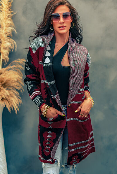 Woman modeling a longline knit cardigan with geometric patterns in maroon, black, and grey, styled with sunglasses and distressed jeans.