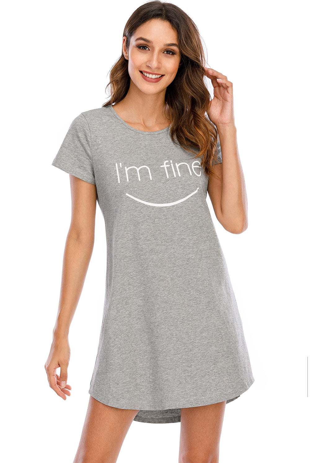 A woman smiles softly, wearing a comfortable heather grey lounge dress with a playful "I'm fine" print accompanied by a smiley face on the front. The dress has a relaxed fit, round neckline, and short sleeves, perfect for a casual, laid-back look.