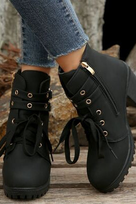 A pair of lace-up ankle boots with a block heel, metal eyelets, and a side zipper, showcasing a versatile style suitable for various outfits.