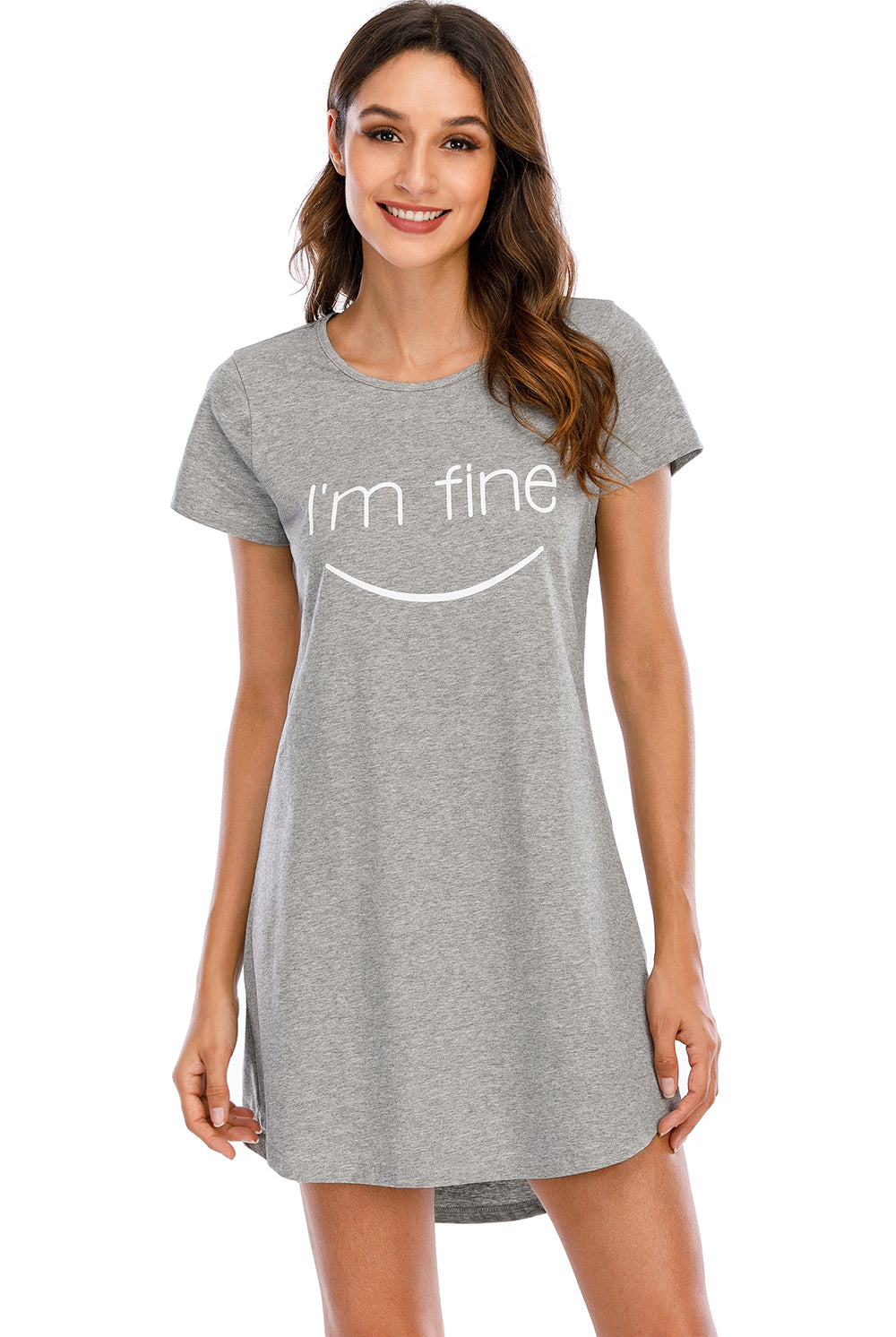 A woman smiles softly, wearing a comfortable heather grey lounge dress with a playful "I'm fine" print accompanied by a smiley face on the front. The dress has a relaxed fit, round neckline, and short sleeves, perfect for a casual, laid-back look.