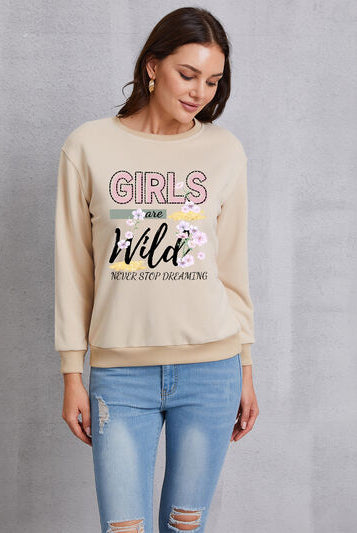 Women's round neck sweatshirt with 'GIRLS ARE WILD NEVER STOP DREAMING' print and floral embroidery.