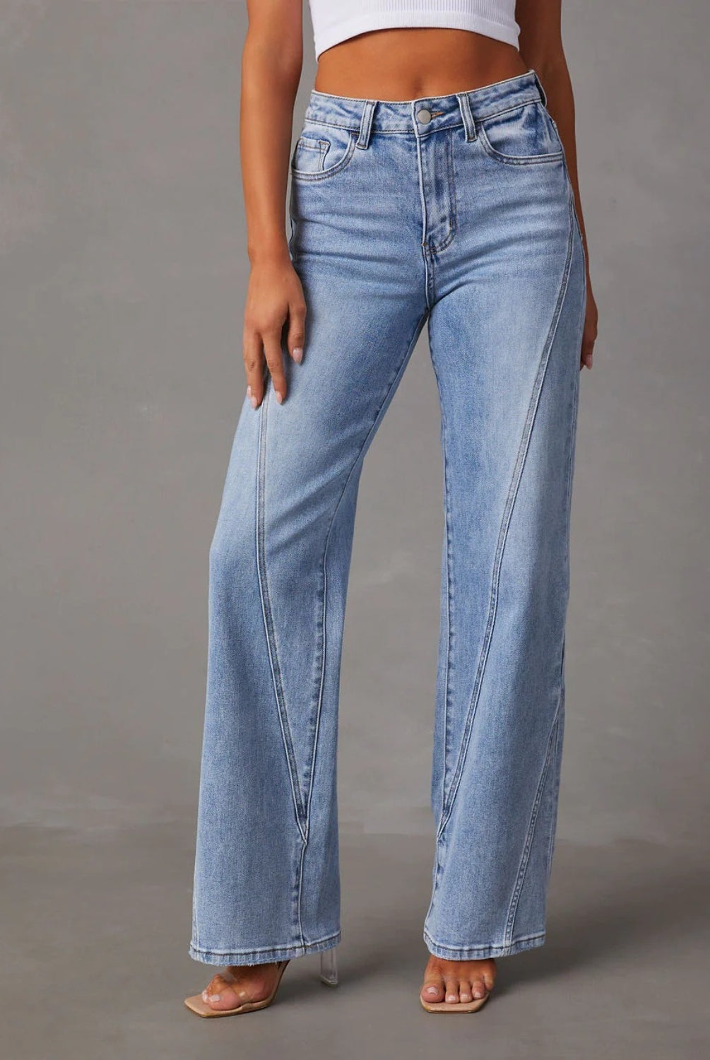 A model showcases Classic High-Waist Straight-Leg Jeans in a light blue wash, complementing the look with a cropped white top and minimalist open-toe heels for an understated yet chic appearance.