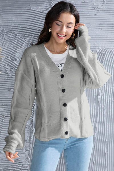 Button up V-neck cardigan with drop shoulders and long sleeves, featuring a ribbed waistband and cuffs, with front button closure for a versatile fit. Perfect for layering over a variety of outfits.