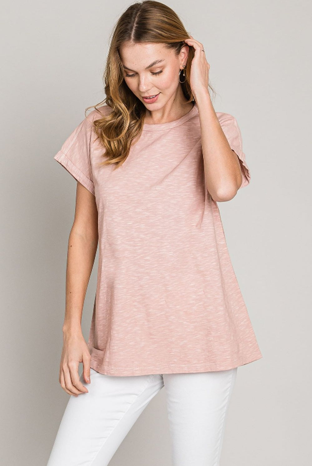 A woman in a casual, mauve cotton t-shirt, paired with white pants for a relaxed and stylish everyday look.