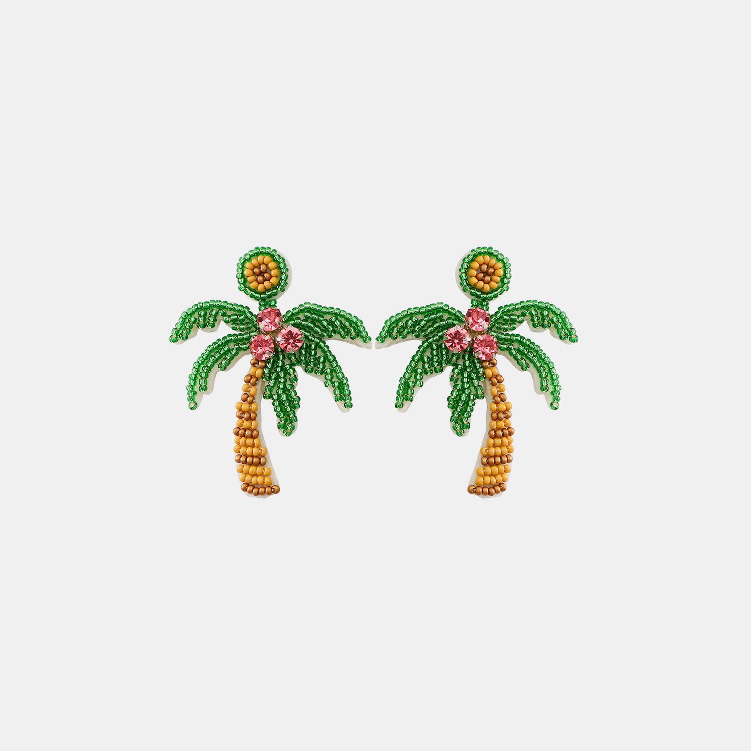 A woman exudes island grace with her stunning coconut tree beaded earrings, complementing her relaxed, seaside style with a touch of tropical elegance.