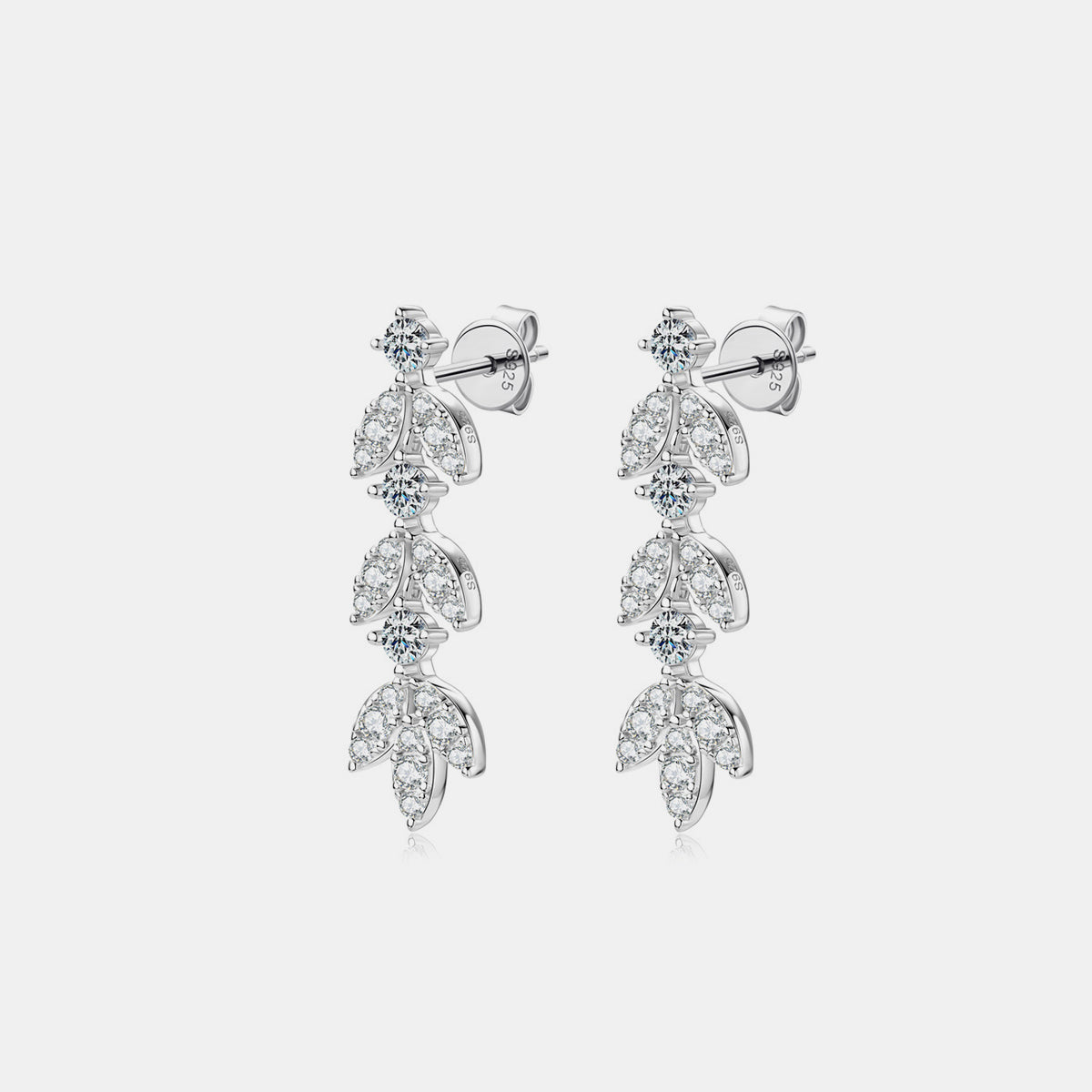 Close-up of a woman wearing elegant sterling silver leaf-shaped earrings, reflecting a subtle sparkle.