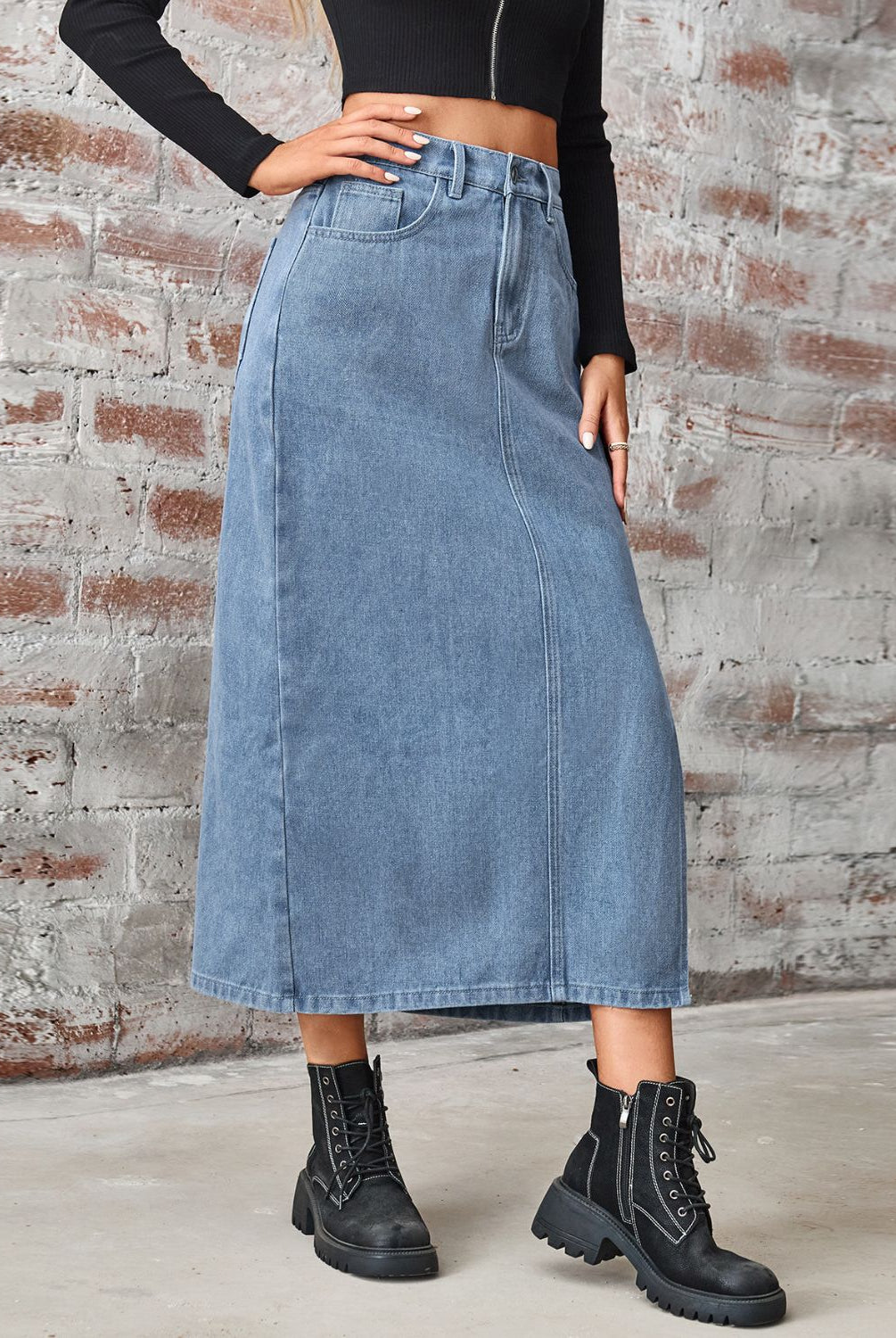 Women's long denim skirt with high waist, slit, and pockets.
