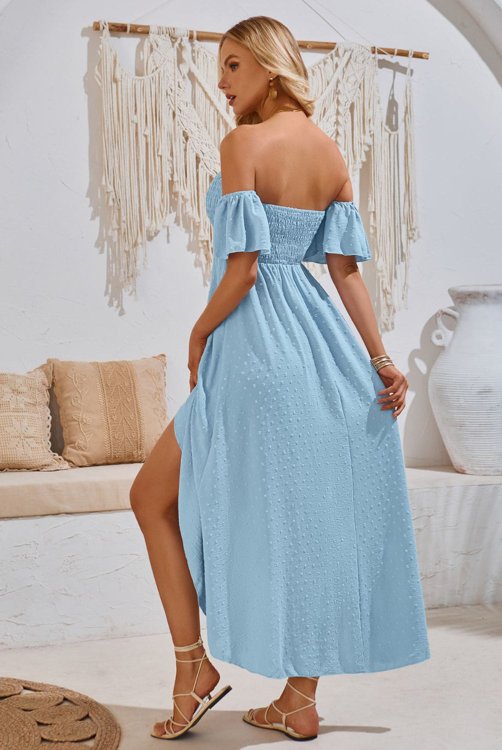 Woman in a chic blue smocked midi dress with a high-low hem, perfect for a summer day.