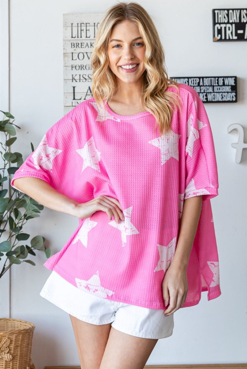 Woman wearing a pink oversized star pattern waffle T-shirt, perfect for casual summer outings.