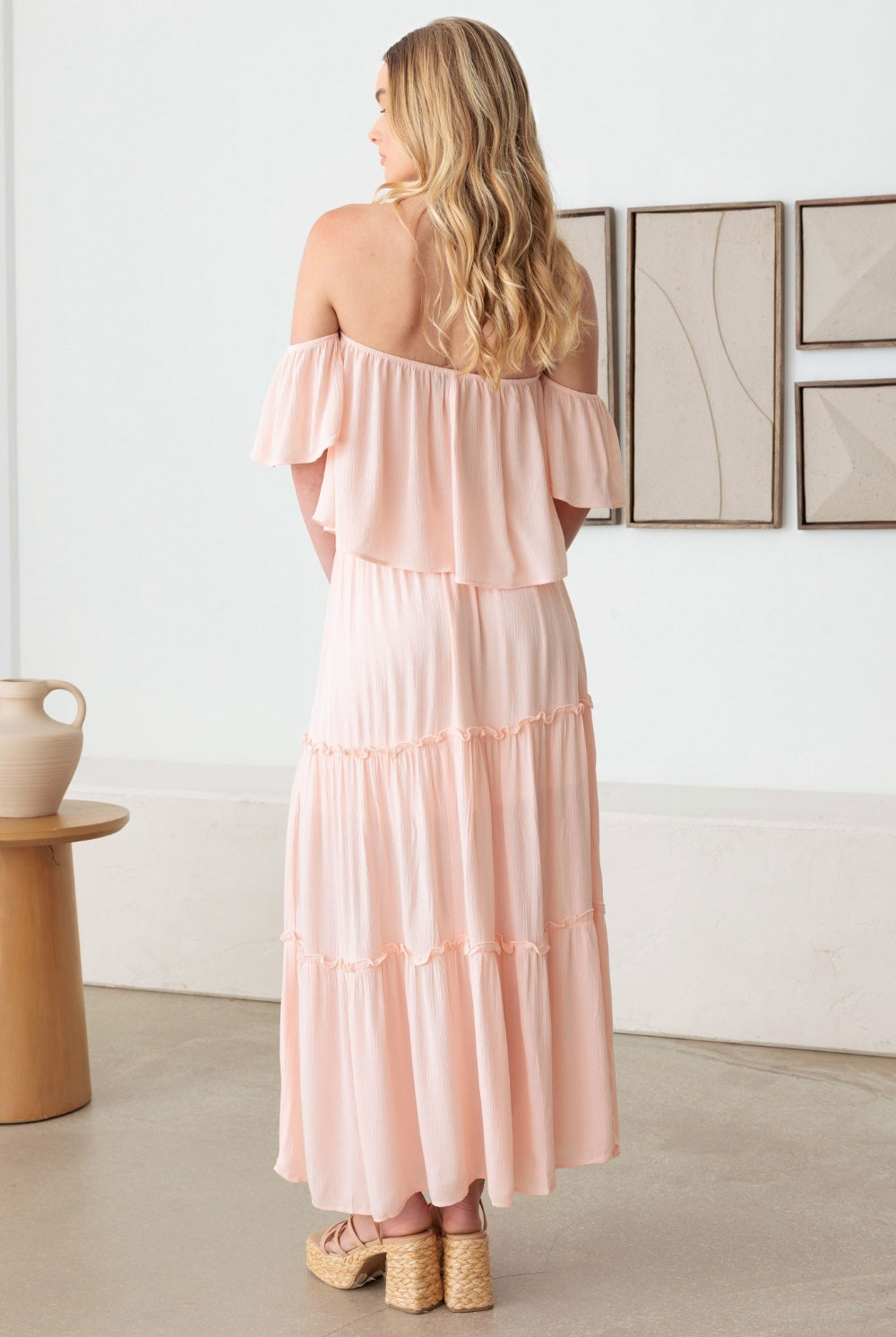 Elegant blush tiered dress with an off shoulder design and frill detailing, perfect for any occasion.