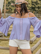 Smiling woman twirling in a purple flare sleeve top with lace accents