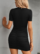 Fashionable woman in a chic black short sleeve dress, accessorized for a stylish day out.