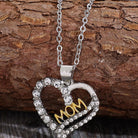 Charming 'Mom' heart pendant necklace with crystals on a rustic wooden backdrop.