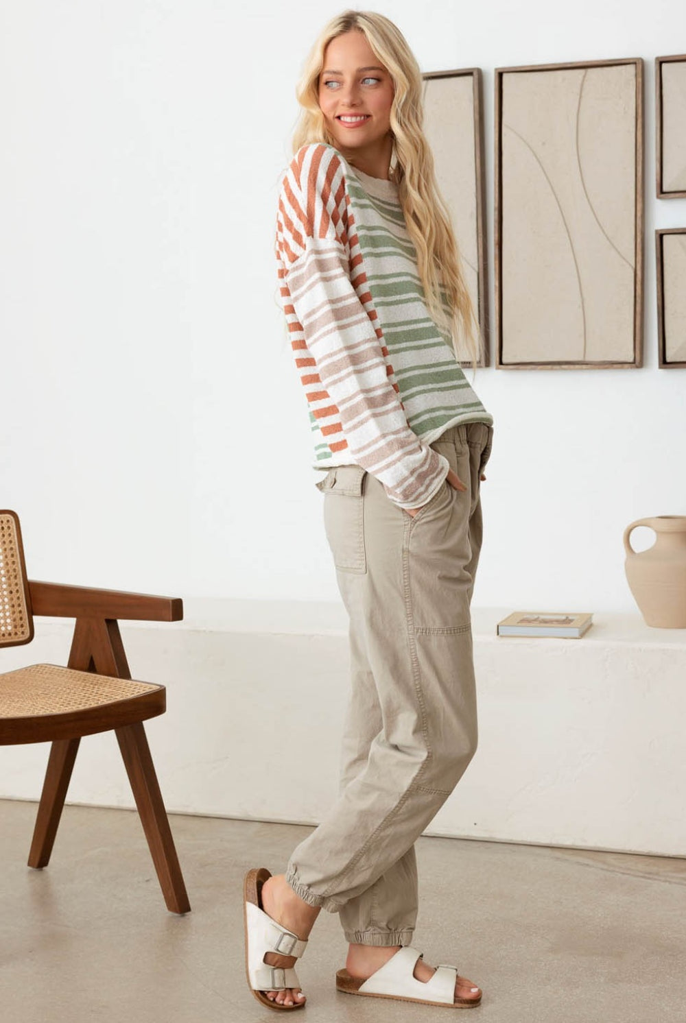 Woman wearing a relaxed multicolor striped long sleeve knit top, epitomizing casual sophistication.