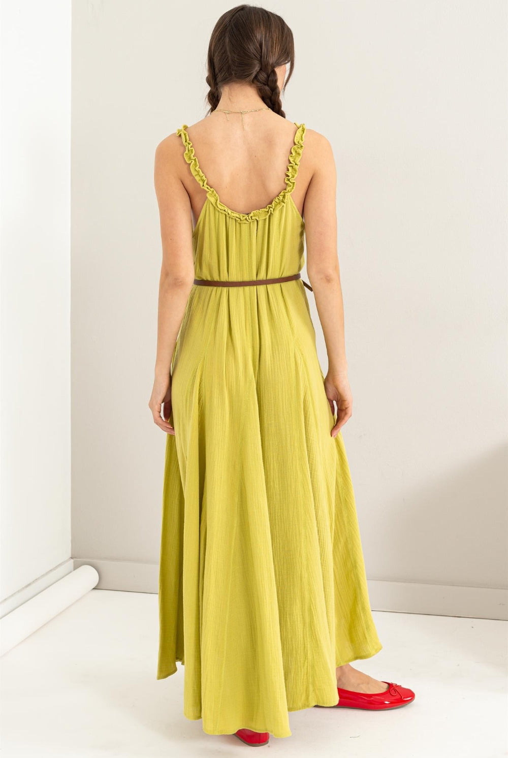 Woman wearing a sleeveless frill maxi dress with a flowy A-line silhouette.