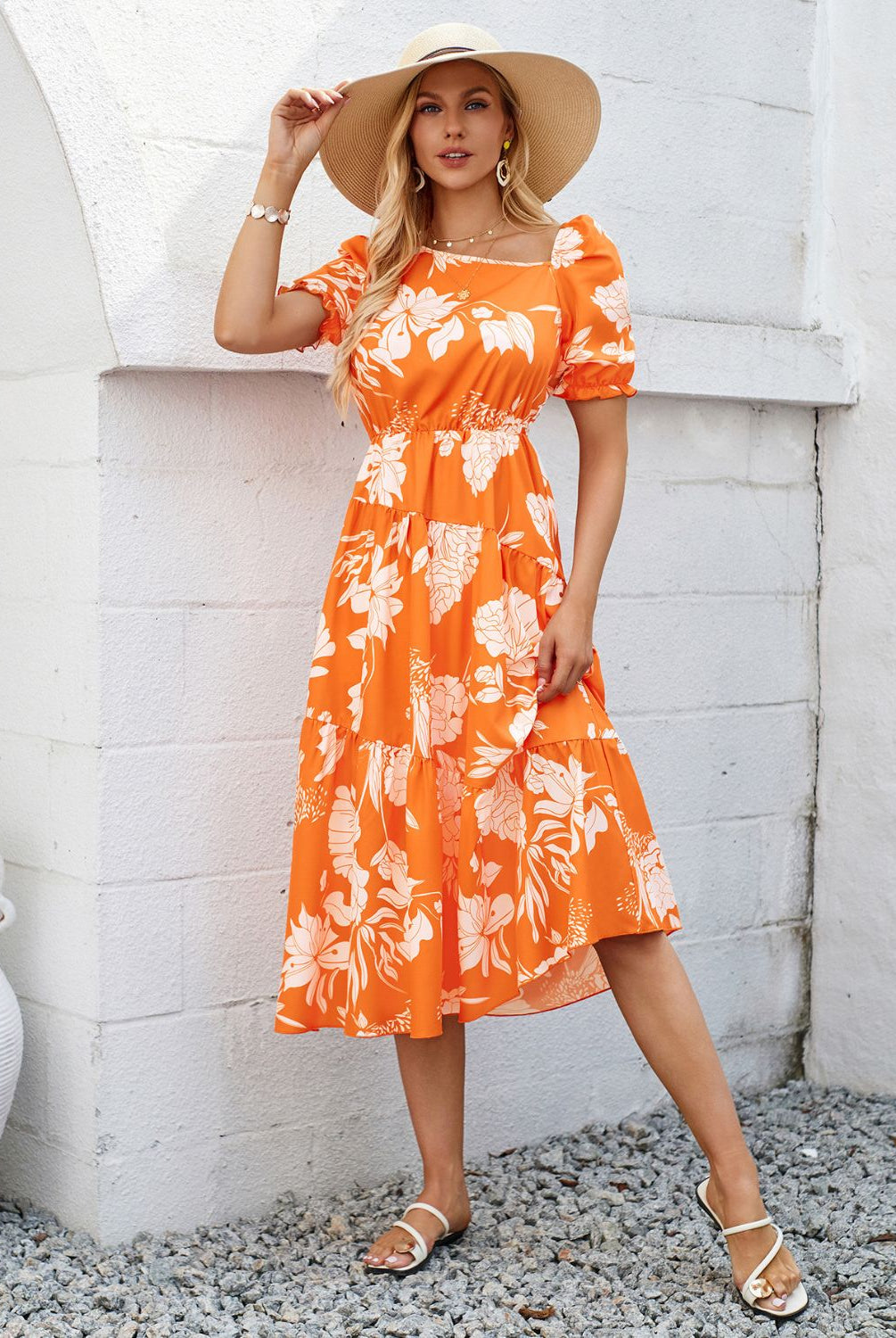 Woman in a vibrant orange floral printed midi dress, perfect for summer.