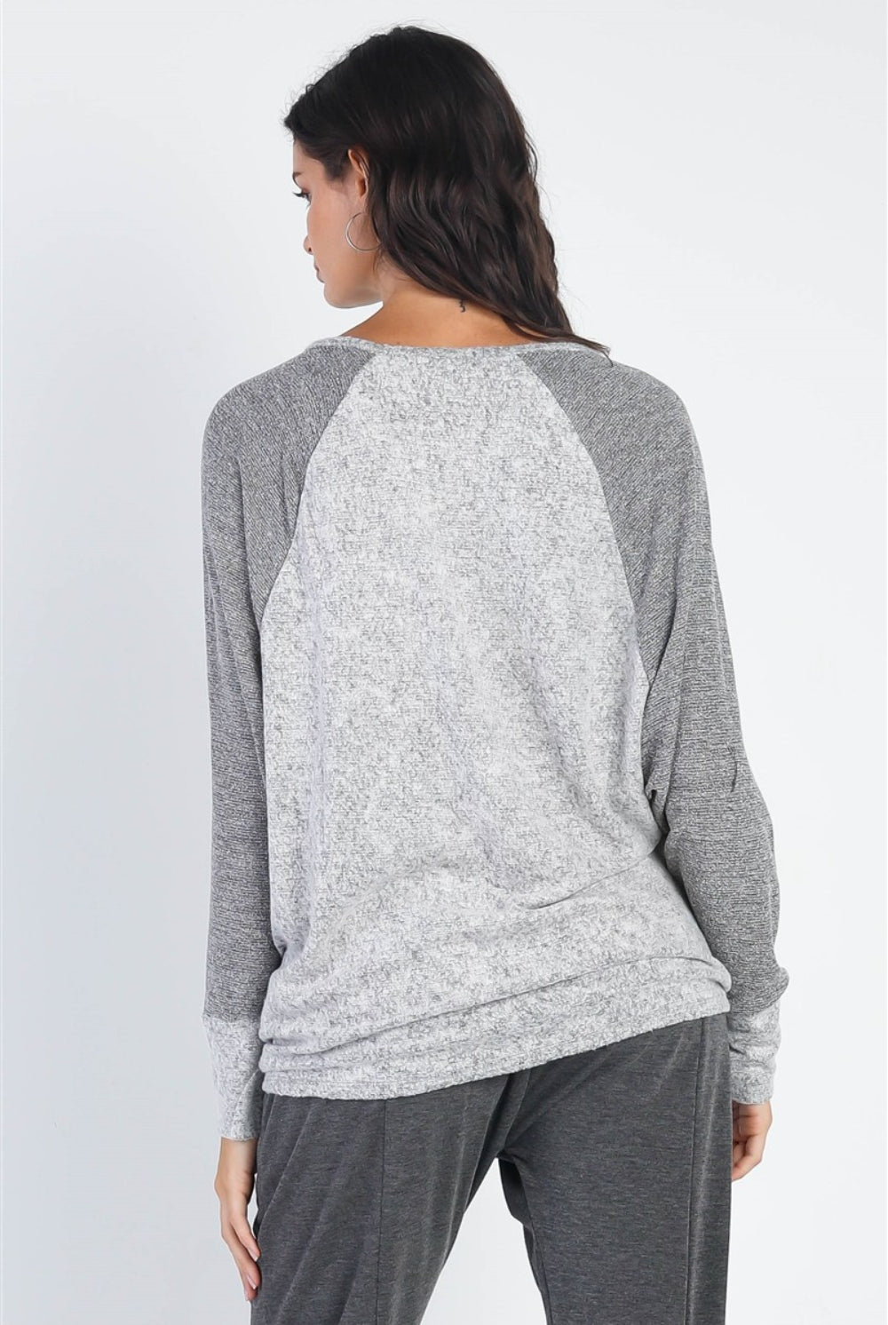 A woman modeling a casual long sleeve contrast top in shades of burgundy and grey, perfect for a stylish yet comfortable outing.