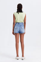 Model showcasing high waist denim shorts with fringed hem